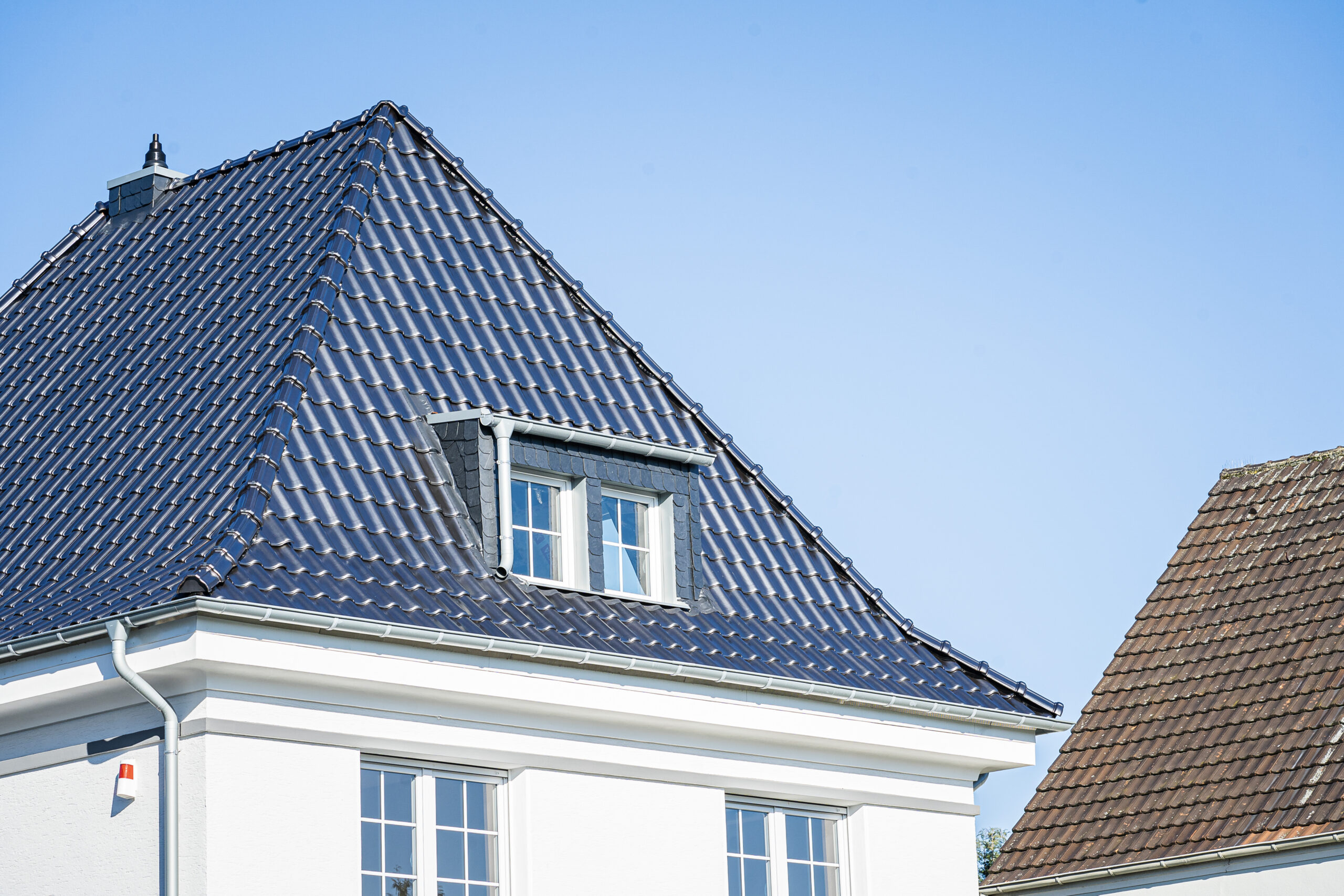 Einfamilienhaus mit blauen Dachziegeln und Gaube